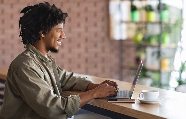 Man working remotely from his laptop in coffee shop